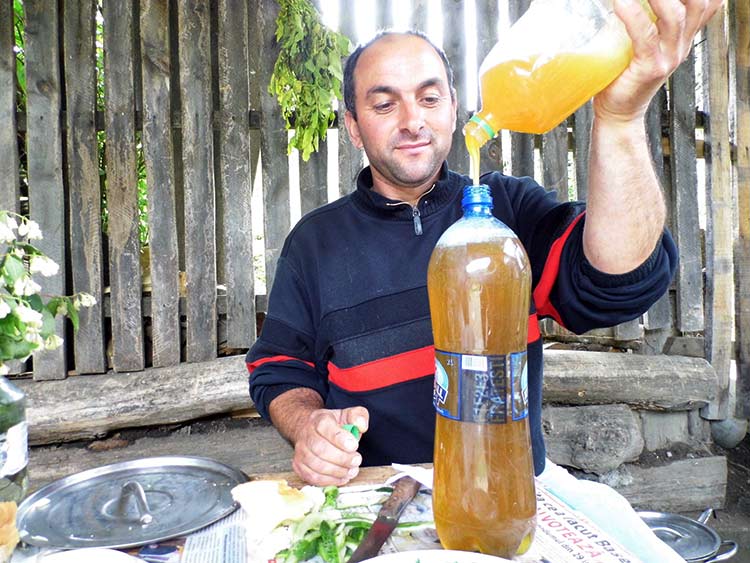 Mann schüttet Honig in eine Flasche