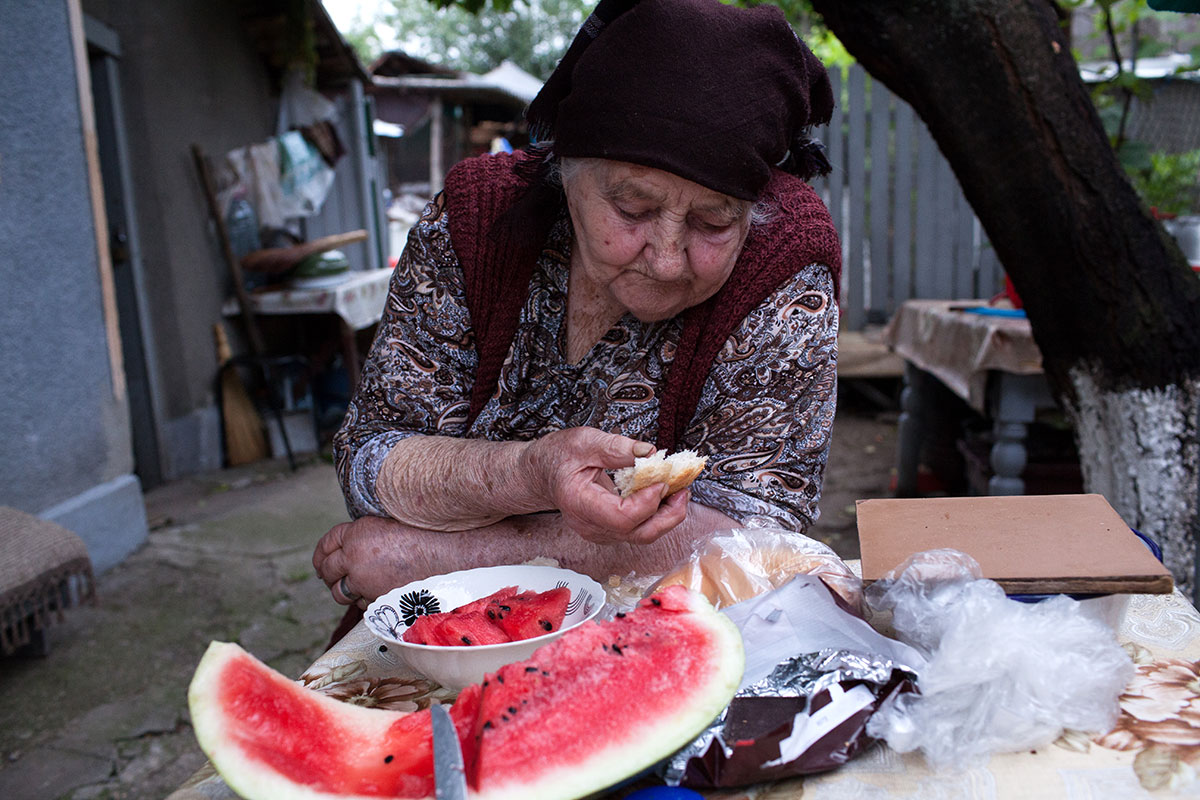 Foto von Melone essender Großmutter