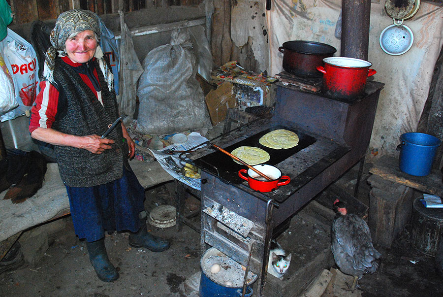 Frau bäckt Eierkuchen auf einem Ofen