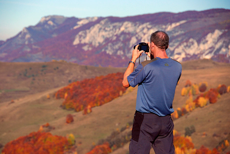Mann fotografiert Herbstlandschaft