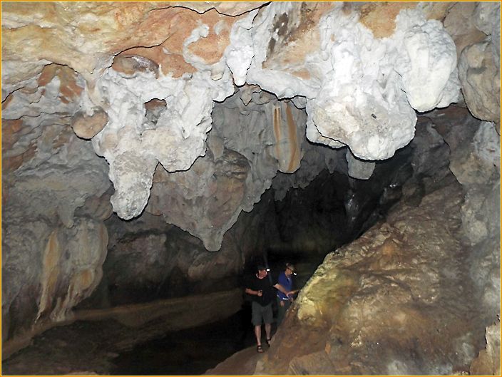 zwei Menschen stehen in einer Höhle neben einem Fluss