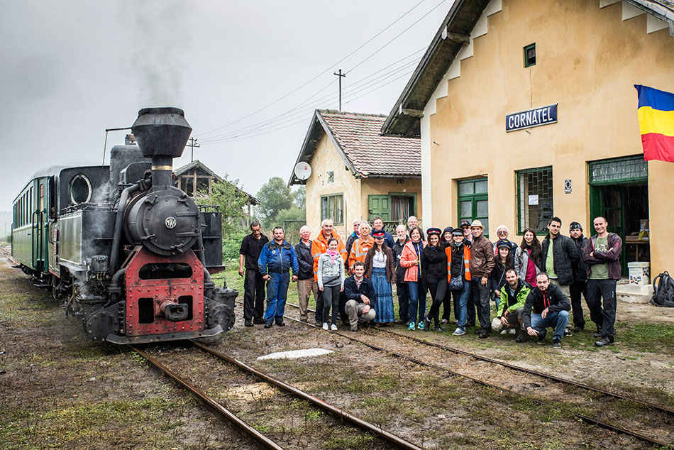 Gruppenfotoe der Freiwilligen vor dem Bahnhofsgebäude von Cornatel und mit Dampflokzug