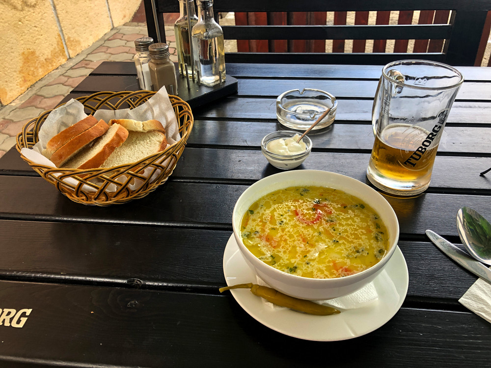 Suppenschüssel mit Brotteller und Bier auf einem Tisch