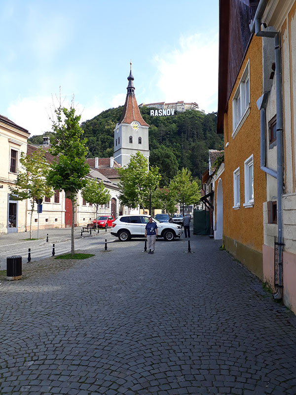 Kirche vor Berghang mit Schriftzug Rasnov im Hintergrund