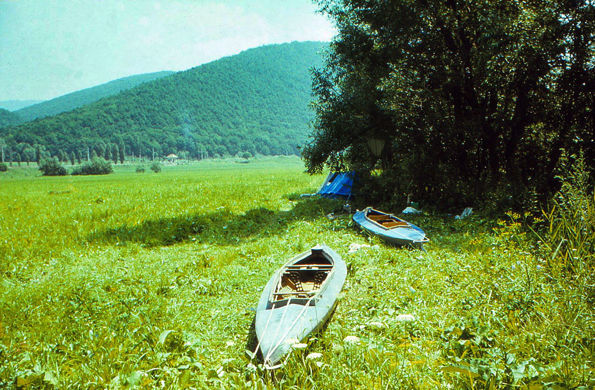 Zwei Faltboote liegen auf einer Wiese