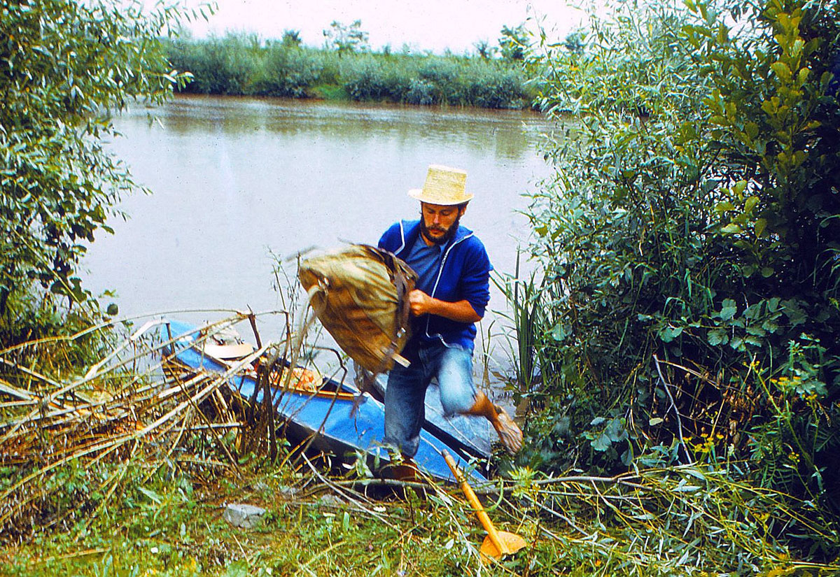 Paddler trägt Gepäck aus einem Boot ans Ufer