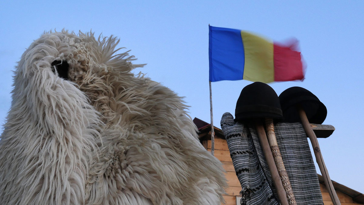 Schaffell und Mützen vor rumänischer Flagge