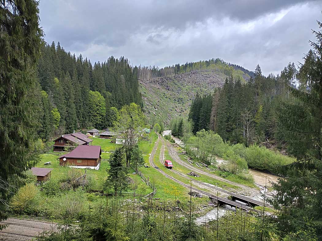 Tal mit Gleisen und Holzhäusern