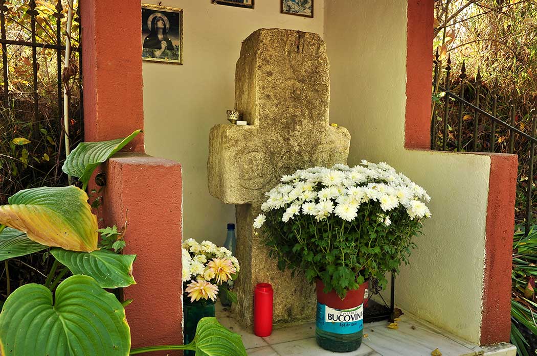 überdachtes Kreuz mit Blumen