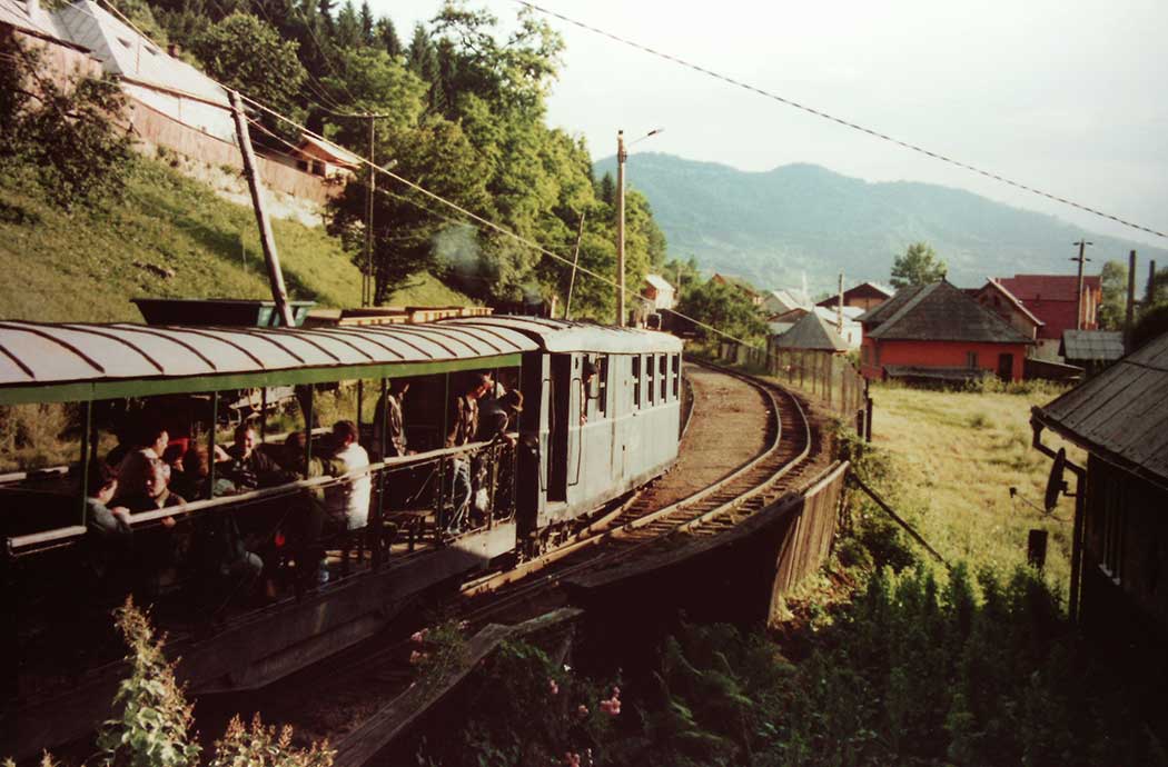 Zug mit offenem Wagen und Menschen besetzt