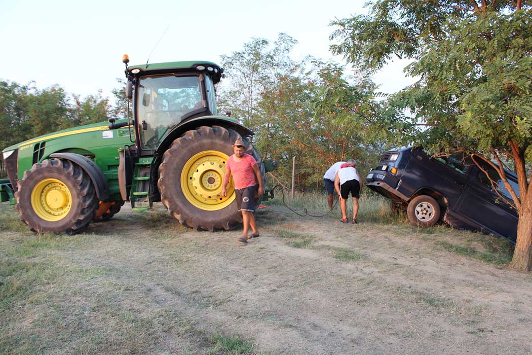 Traktor vor dem Auto im Graben