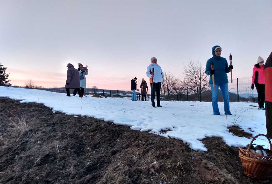 Menschen mit Fackeln auf einer verschneiten Wiese