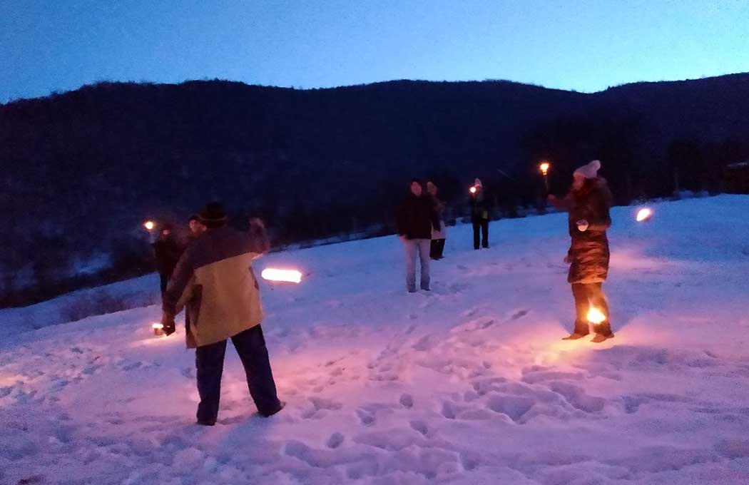 Menschen mit Facken auf einer Wiese