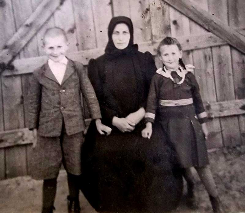 Mutter mit Kindern vor einem Tor