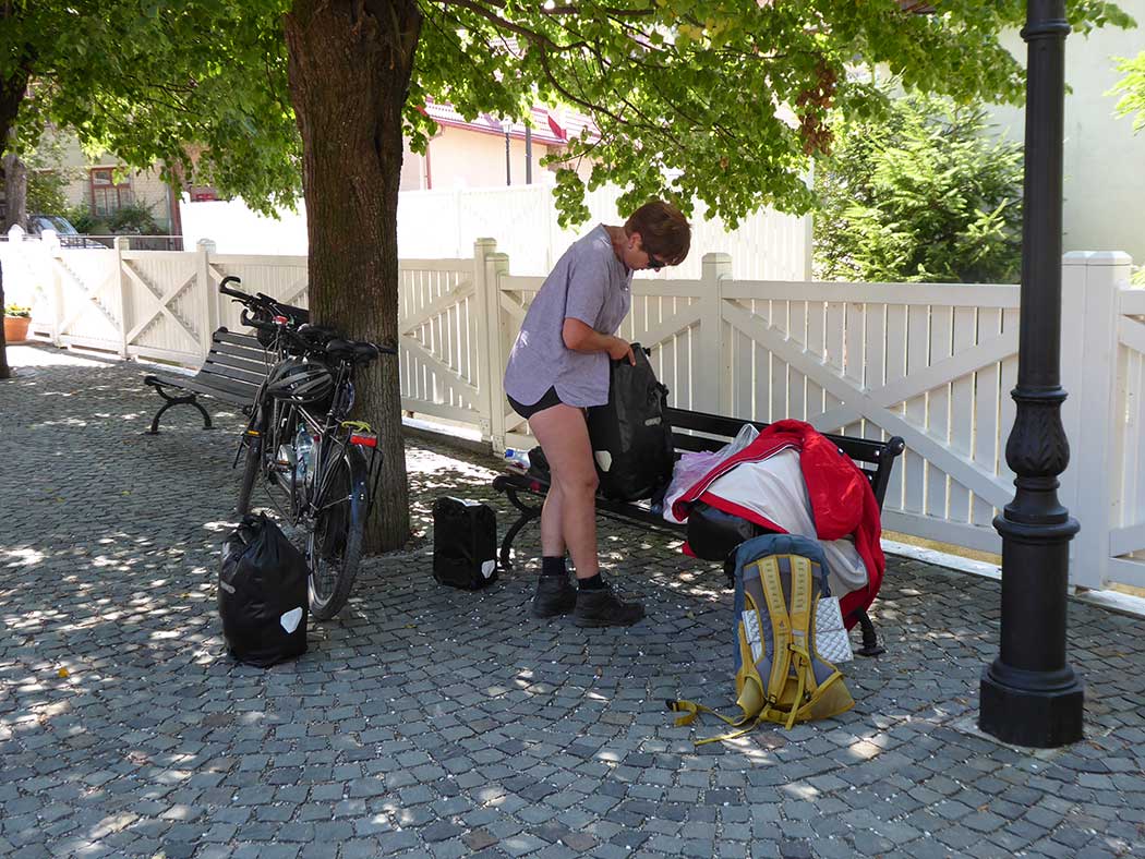 Frau packt Fahrradtasche auf einer Bamk
