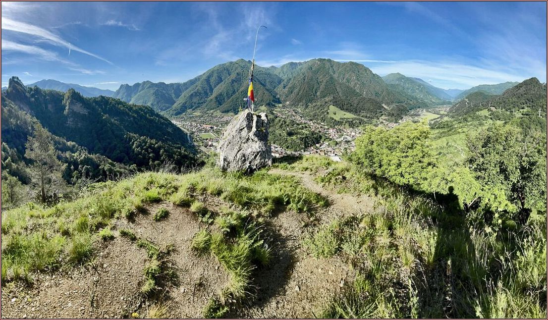 Gipfelkreuz mit rumänischer Fahne vor Berglandschaft