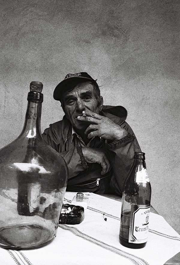 Mann mit Zigarette an einem Tisch sitzend