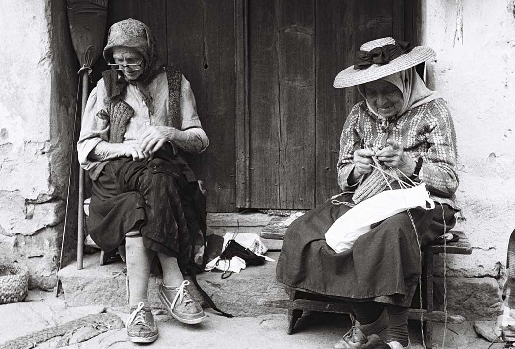 Frauen vor einem Tor sitzend