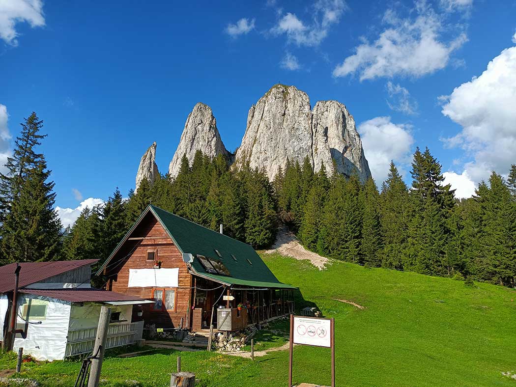 Bergwiese mit Hütte und Berggipfeln