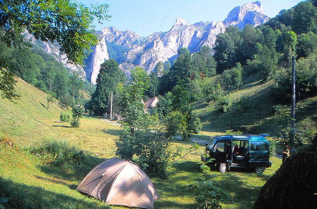 Auto und Zelt in enem Flusstal