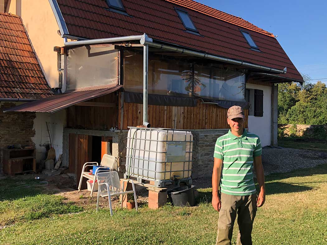 Mann steht vor einem Haus